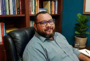 Psicologo humanista André Neto em seu consultório, pronto para atender com Gestalt Terapia online